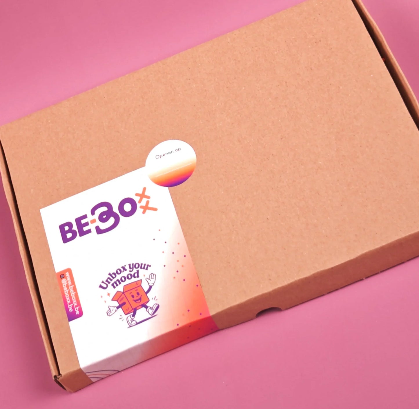 Bruine cadeaubox met sticker en vrolijke illustratie op roze achtergrond, themabox verpakking