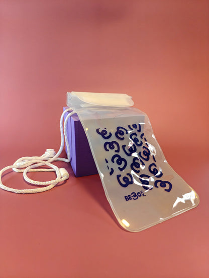 Paarse cadeauverpakking met doorzichtig waterdicht tasje, wit koord, op roze ondergrond