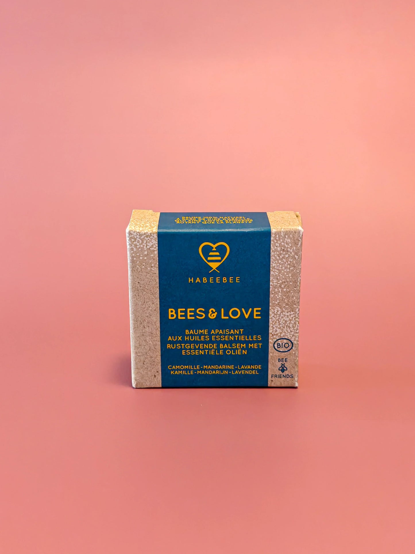 Bees & Love balsem met essentiële oliën in kartonnen verpakking tegen roze achtergrond