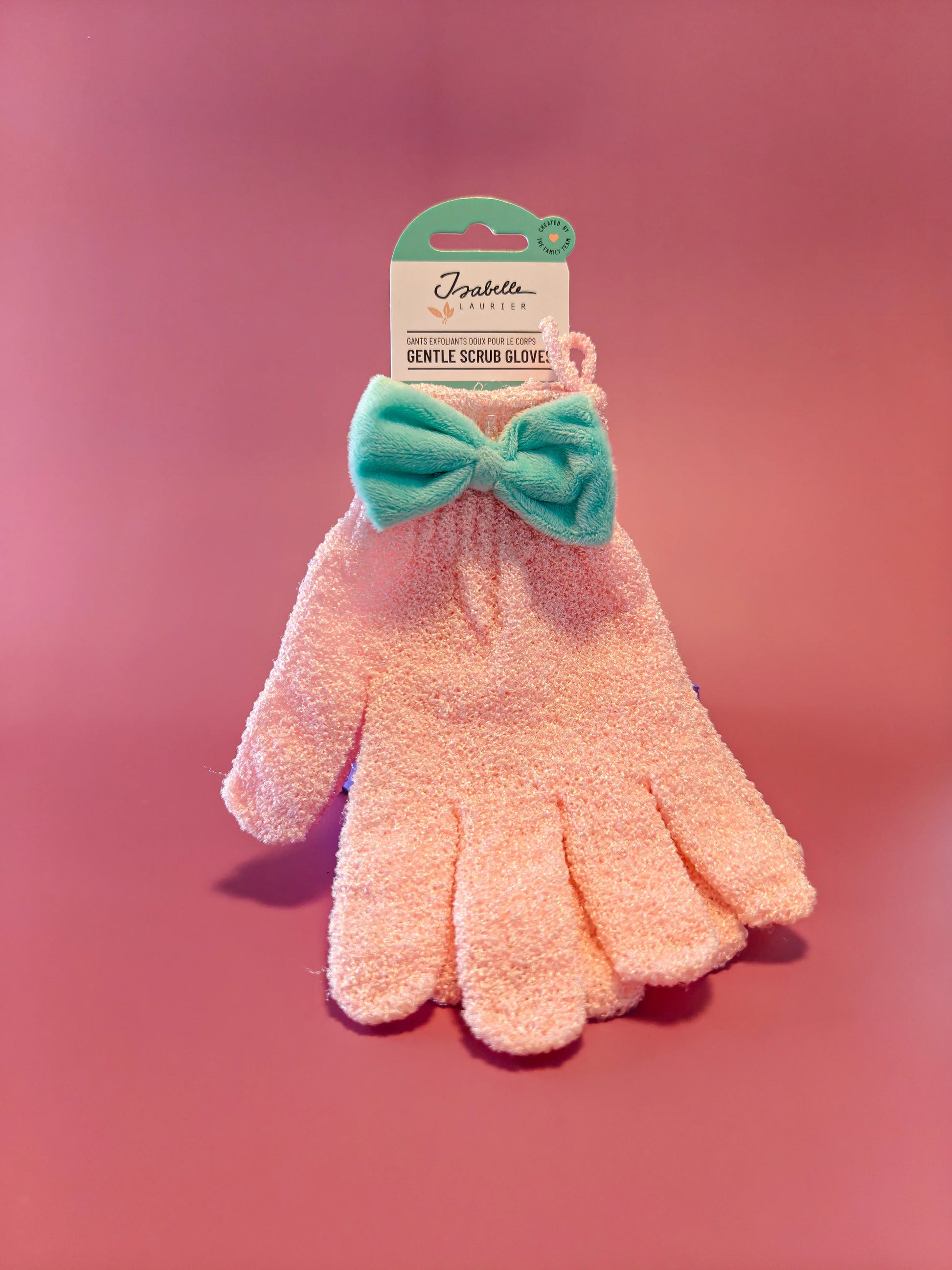 Roze scrubhandschoen met turquoise strik, verpakt op roze achtergrond, lichaamsverzorging