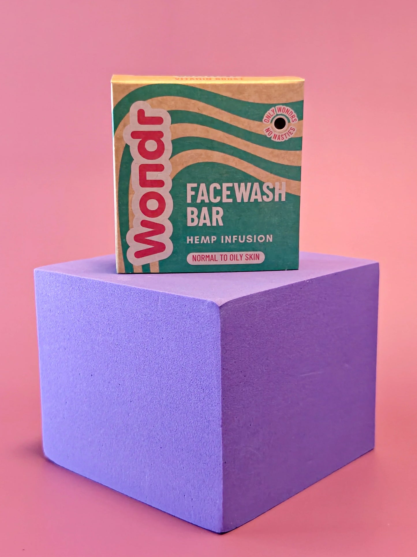 Wondr facewash bar verpakking met hennep, voor normale tot vette huid, op paarse kubus tegen roze achtergrond