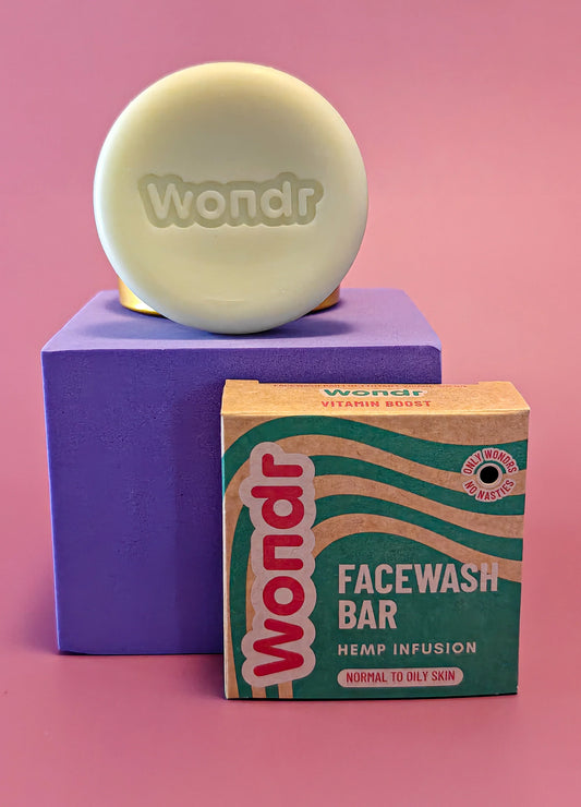 Wondr facewash bar en verpakking voor normale tot vette huid op paarse kubus met roze achtergrond