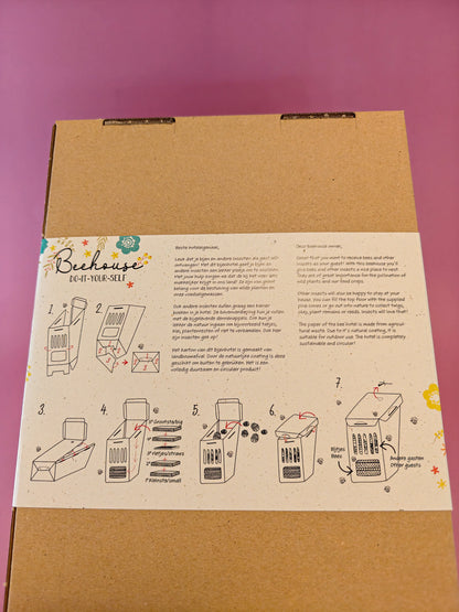 Beehouse DIY bijenhotel bouwpakket op kartonnen doos, instructies met illustraties, paarse achtergrond