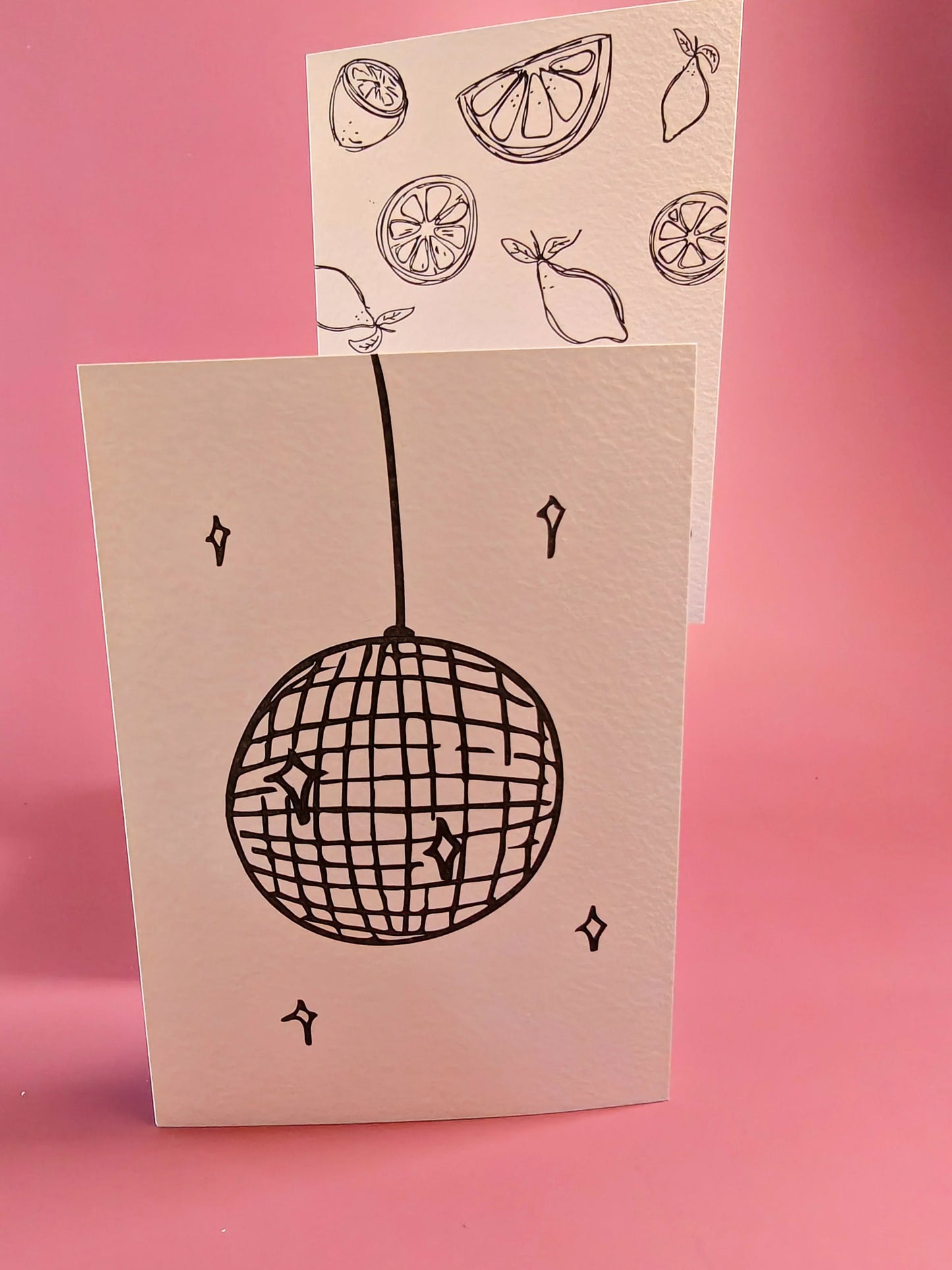 Wenskaart met discobal en citroentekeningen op roze achtergrond, minimalistisch design.