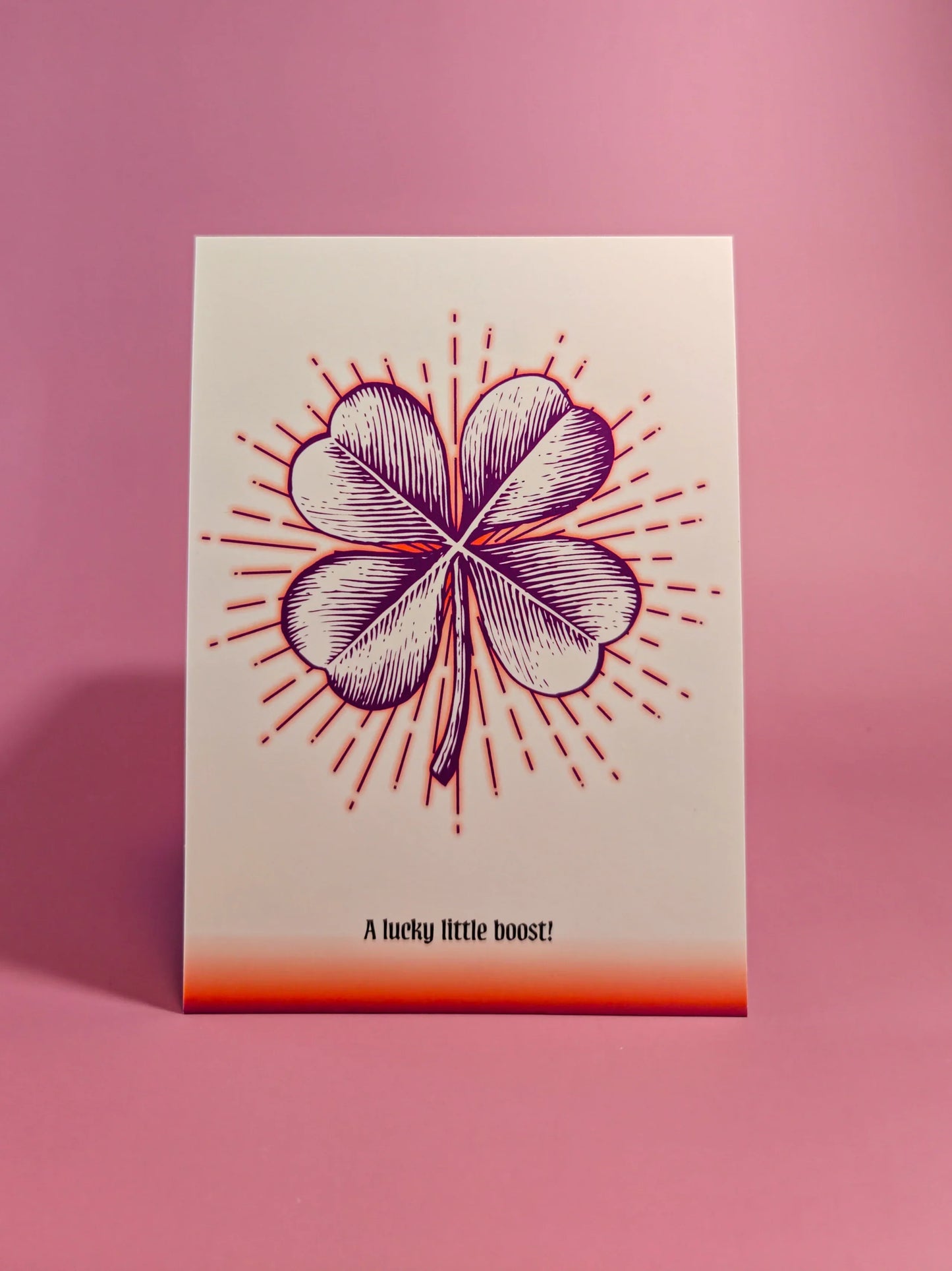 Wenskaart met vierklaver en tekst 'A lucky little boost!' op roze achtergrond, cadeaukaart geluk.
