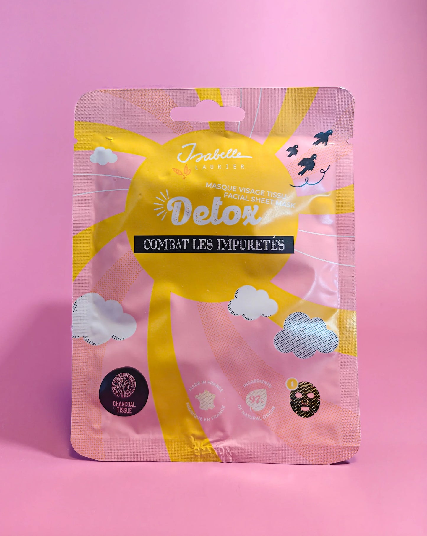 Gezichtsmasker Detox verpakking tegen onzuiverheden met zon en wolken op roze achtergrond.