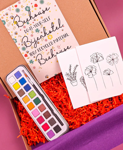 DIY bijenhotel knutselpakket met waterverf, penseel, bloemenkaarten en instructiekaart.