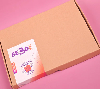 Cadeaubox van bruin karton met kleurrijke sticker op een roze achtergrond