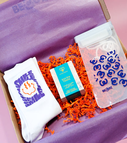 Cadeaubox met witte sokken, tonic zeep en doorzichtig etui op paarse en oranje vulling